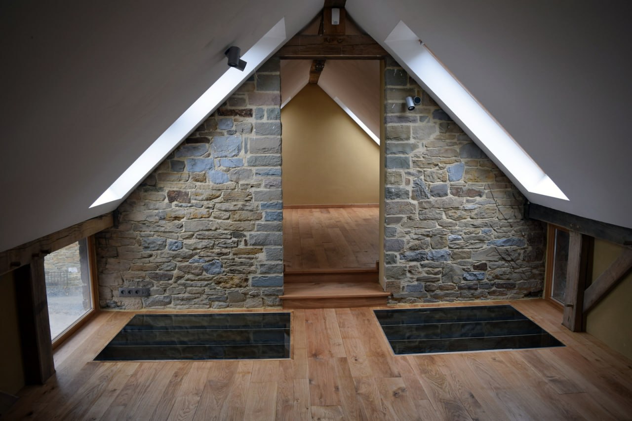 Plancher chêne massif — grenier rénovation avec trappes et mur en pierres