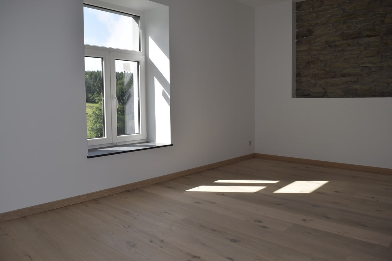 Plancher chêne clair — chambre avec mur en pierres apparentes