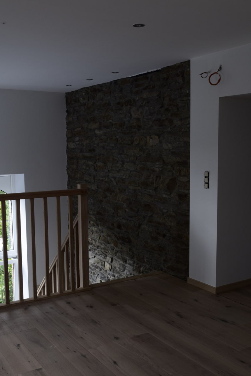 Plancher chêne — palier avec escalier bois et mur en pierres